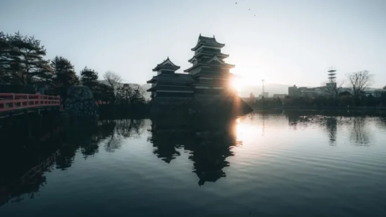 Castle reflected in water at sunset